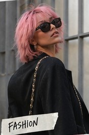 Asia in sunglasses and a black blazer by a window